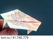 Rubles and dollars on fire in the form of paper airplanes, concessionary and sanctions. Стоковое фото, фотограф Igor Skripachev / Фотобанк Лори