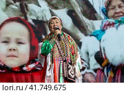 Женщина в национальной одежде из Ханты-Мансийского автономного округа исполняет песню со сцены на Международной выставке-форуме "Россия" на ВДНХ в городе Москве, Россия (2023 год). Редакционное фото, фотограф Николай Винокуров / Фотобанк Лори
