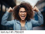 A young girl with curly hair rejoices in luck with her fists raised up. Generated by AI. Стоковое AI-изображение, AI-художник Ярославский Максим / Фотобанк Лори
