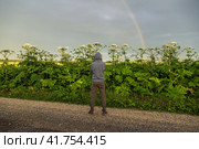 Man near Giant Hogweed Sosnowski plant. Heracleum manteggazzianum growing in the field. Стоковое фото, фотограф Ольга Сейфутдинова / Фотобанк Лори