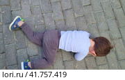 A capricious child lies on the ground in cry refusing to go. Baby aged two years (two-year-old boy) Стоковое видео, видеограф Андрей Журавлев / Фотобанк Лори