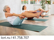 Senior woman performs boat asana - Paripurna navasana. Стоковое фото, фотограф Яков Филимонов / Фотобанк Лори