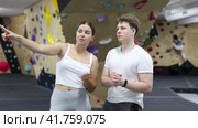 Girl gym coach and teen client talking in fitness room discussing possible options climbing. Стоковое видео, видеограф Яков Филимонов / Фотобанк Лори