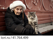 An elderly woman, a pensioner, on the street on a bench with a cat at the entrance.,  Generative AI. Стоковое AI-изображение, AI-художник Анна Кривицкая / Фотобанк Лори