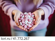 Women's hands hold a handful of mixed red and white pills. The concept of choice. Стоковое AI-изображение, AI-художник Ярославский Максим / Фотобанк Лори