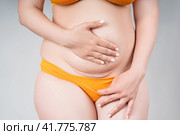 Female belly with a scar from a caesarean section close-up on a gray background. Стоковое фото, фотограф Станислав Тарко / Фотобанк Лори