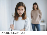 Close up upset girl in front and woman behind avoid to talk after quarrel at home, offended teen daughter and young aged mum argument, two generation conflict concept. Стоковая иллюстрация, иллюстратор Оксана Гильман / Фотобанк Лори