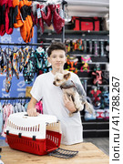 Teen boy choose carrier for small pet Yorkshire terrier dog. Стоковое фото, фотограф Яков Филимонов / Фотобанк Лори