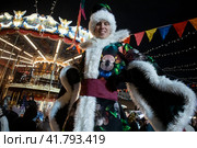 Артисты в разноцветном карнавальных костюмах во время праздничных предновогодних мероприятий на ГУМ-ярмарке на Красной площади в центре города Москвы, Россия (2023 год). Редакционное фото, фотограф Николай Винокуров / Фотобанк Лори