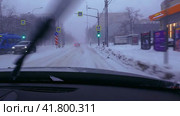A first-person view from the windshield of a car while driving around the city in heavy snowfall. Russian. Moscow. 02.12.23 (2023 год). Стоковое видео, видеограф Ярославский Максим / Фотобанк Лори