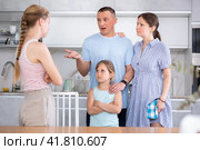 Disgruntled parents reprimanding eldest teenage girl in home kitchen. Стоковое фото, фотограф Яков Филимонов / Фотобанк Лори