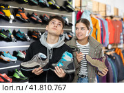 Couple examine view several item of winter comfortable trecking shoes. Стоковое фото, фотограф Яков Филимонов / Фотобанк Лори