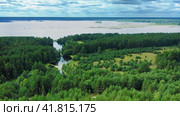 A marshy riverbed flowing into a large lake. The water in the creek is covered with cassava and algae, and islands are visible on the lake in the distance. There are small bridges across the river. Стоковое видео, видеограф Даниил Хабаров / Фотобанк Лори