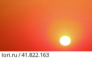Sunset of the yellow sun in a clear cloudless sky, timelapse. The big sun sinks below the horizon in the evening red sky at dusk, timelapse. Стоковое видео, видеограф Андрей Журавлев / Фотобанк Лори
