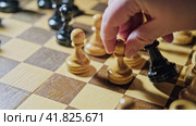 The capture of the bishop by the white pawn in a chess game. Man hand with a chess piece in a board game. Стоковое видео, видеограф Андрей Журавлев / Фотобанк Лори