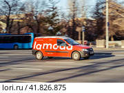 Delivery red van of the Russian online store Lamoda. Side view of car with Lamoda logo. Courier rides on highway city road (2021 год). Редакционное фото, фотограф Константин Григорьев / Фотобанк Лори