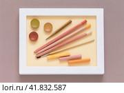 Drawing and creativity as a hobby. Pencils, watercolor paints, brush and pastel sticks in warm pink and peach tones in a white frame. Shades of trendy color Peach Fuzz. Flat lay, close-up, top view. Стоковое фото, фотограф Виктория Катьянова / Фотобанк Лори