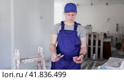 Discontented teenager boy holding bunch of money he earned by working on his first job in construction site. Стоковое видео, видеограф Яков Филимонов / Фотобанк Лори