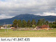 the village of Verkhnearshinsky in the Beloretsk region of Bashkortostan against the backdrop of the Kumardak ridge on a cloudy day. Стоковое фото, фотограф Акиньшин Владимир / Фотобанк Лори