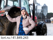 Portrait of woman next to tractor in the backyard of farm. Стоковое фото, фотограф Яков Филимонов / Фотобанк Лори