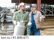 Farmer couple standing with milk churn at livestock farm and talking. Стоковое фото, фотограф Яков Филимонов / Фотобанк Лори