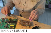 Close up woman hands Soldering a micro chip processor with iron tool on a green circuit boad. Electroncs service technology and macro computer concept background. Стоковое видео, видеограф Ирина Старикова / Фотобанк Лори