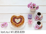 Homemade heart-shaped cake, two cups of coffee, gifts in boxes and a bouquet of flowers on a white table. Beautiful congratulations on Valentine's Day or Happy Birthday. Flat lay, copy space, top view, close-up, mock up. Стоковое фото, фотограф Виктория Катьянова / Фотобанк Лори