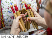 Крупным планом мастерица ткет михайловское кружево на стенде Рязанской области на выставке-форуме "Россия" в городе Москве, Россия (2023 год). Редакционное фото, фотограф Николай Винокуров / Фотобанк Лори
