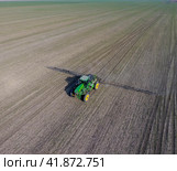 Tractor with hinged system of spraying pesticides. Fertilizing with a tractor, in the form of an aerosol, on the field of winter wheat. Стоковое фото, фотограф Леонид Еремейчук / Фотобанк Лори
