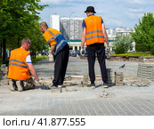 Рабочие ремонтируют старое тротуарное покрытие (2023 год). Редакционное фото, фотограф Вячеслав Палес / Фотобанк Лори