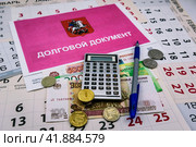 Долговой документ за неуплату жилищно-коммунальных услуг (ЖКУ), деньги, калькулятор, ручка лежат на листках календаря. Стоковое фото, фотограф Владимир Устенко / Фотобанк Лори