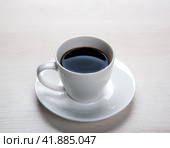 White cup with black coffee and saucer on the table. Стоковое фото, фотограф Александр Калугин / Фотобанк Лори