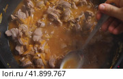 Женская рука зачерпывает бульон из куриной говядины с овощами, приготовленный в воке, и пробует его ложкой. Крупный план. Приготовление пищи в азиатском стиле. Стоковое видео, видеограф Воловодов Владимир / Фотобанк Лори