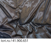 Abstract grey silk background, the fabric is covered with waves. Black background is a luxurious wave texture fabric. Crumpled silver metallized fabric with regular pattern. Background, texture. Стоковое фото, фотограф Александр Кротков / Фотобанк Лори