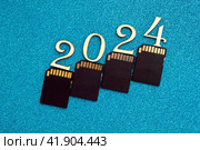 Коллаж защита информации в 2024 году. Лесенка из карт памяти и цифр года на синем фоне. Стоковое фото, фотограф Елена Бобкова / Фотобанк Лори
