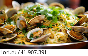 Spaghetti alle vongole with tomato in seafood jus served as close-up at a Nordic design bowl with copy space. Стоковое AI-изображение, AI-художник Ирина Ручушкина / Фотобанк Лори