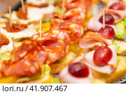 Канапе с колбасой, мясом, салатом, сыром, огурцами и виноградом.  Закуска на шпажках. Стоковое фото, фотограф Pukhov K / Фотобанк Лори