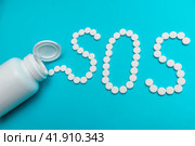 White tablets on a blue background laid out in the form of letters SOS. Стоковое фото, фотограф Ярославский Максим / Фотобанк Лори