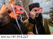 Мужчины надевают карнавальные маски во время проведения фестиваля "Усадьбы Москвы. Зима" в атмосфере предновогодней Москвы XIX века, Россия (2023 год). Редакционное фото, фотограф Николай Винокуров / Фотобанк Лори