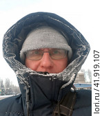 Severe frosts outside. A frostbitten man in a winter jacket on the street. Стоковое фото, фотограф Александр Поташев / Фотобанк Лори