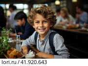 Portrait of schoolboy having lunch during break time in school cafeteria. Стоковое AI-изображение, AI-художник Ирина Михайличенко / Фотобанк Лори