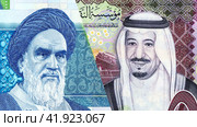 Saudi Arabia Riyal banknote with King Salman and Iranian rial banknote with Ayatollah Khomeini. Стоковое фото, фотограф FotograFF / Фотобанк Лори