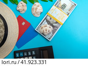 Платежные карты МИР и VISA с соломенной шляпой пачкой долларов и калькулятором на голубом фоне. Концепция отпускных расходов. Стоковое фото, фотограф Ярославский Максим / Фотобанк Лори