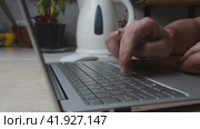 Male hands are typing on a laptop keyboard at the kitchen table. Стоковое видео, видеограф Ярославский Максим / Фотобанк Лори