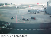 Istanbul, Turkey 01.01.24: Runway. The territory of the international airport IST Havalimani. Cars, trucks, cars are moving. Telescopic bridge or hose for disembarking and embarking passengers. Редакционное фото, фотограф Юлия Петровская / Фотобанк Лори