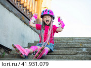 Little happy pretty girl on roller skates in helmet at a park. Cheerful preschool girl wearing inline roller skates and protective equipment. High quality photo. Стоковое фото, фотограф Ирина Михайличенко / Фотобанк Лори