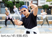 Portrait of emotional girl doing hip hop movements during group class at street. Стоковое фото, фотограф Яков Филимонов / Фотобанк Лори