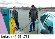 Russia Samara November 5, 2010: mature men refuel a car at an old Rosneft gas station. text in Rosneft. Редакционное фото, фотограф Акиньшин Владимир / Фотобанк Лори