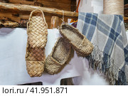 Берестяные и лыковые лапти висят на полке около русской печи в старинной избе. Музей русской печи. Стоковое фото, фотограф Сергей Никифоров-Гордеев / Фотобанк Лори