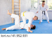 Senior man, karate sensei, engaging kumite with young guy in training room. Стоковое фото, фотограф Яков Филимонов / Фотобанк Лори